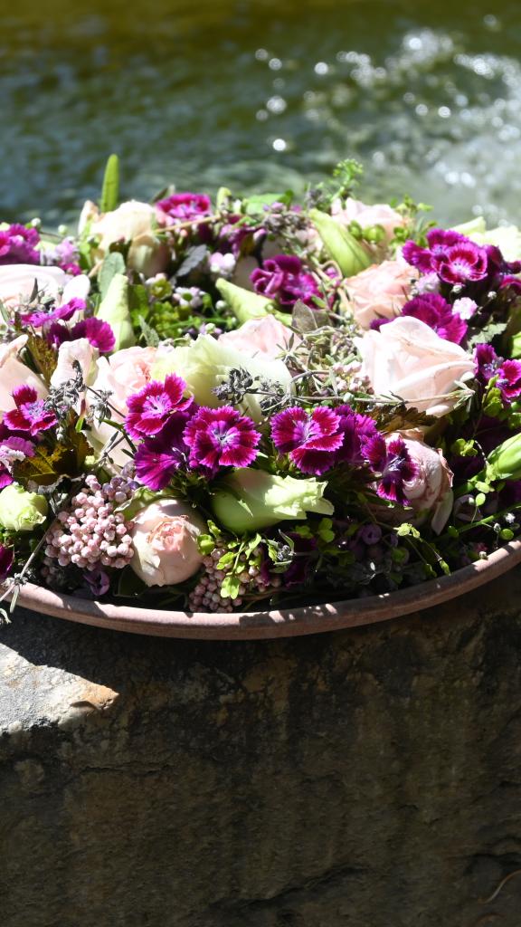 Blumengesteck auf Brunnenrand